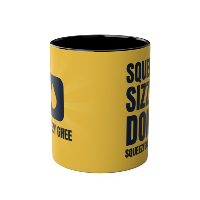 Butter-yellow mug with a black rim and handle, the mark on one face and Squeeze. Sizzle. Done. on the other.
